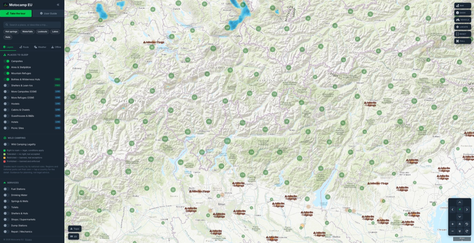 The Alps along the Italian and Swiss border in Motocamp EU, covered in numbered clusters of campsites, aires and mountain refuges, with live rain radar over eastern Switzerland and active fire labels across Lombardy and the Veneto.